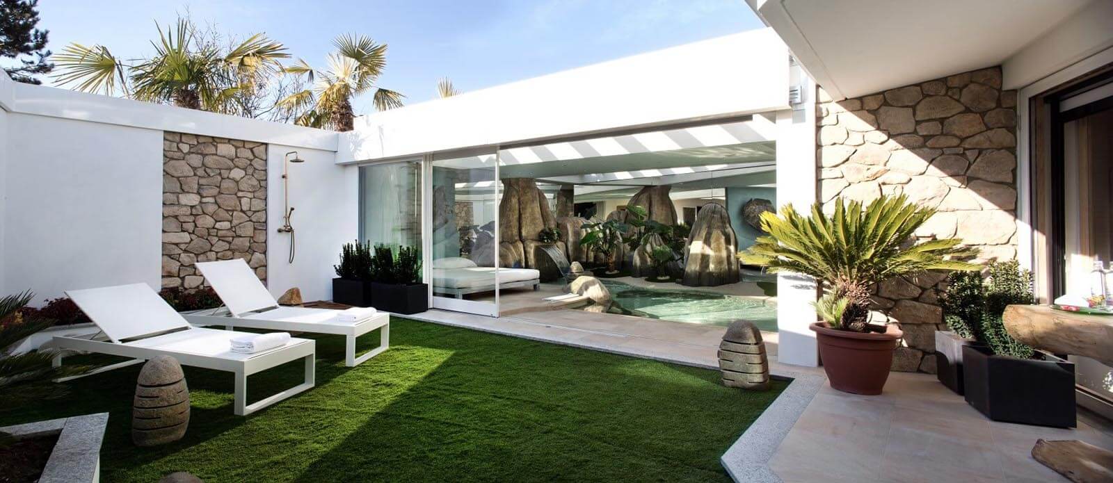 Motel K Pool Villa Seychelles Motel K Pool Villa Seychelles vista sul giardino esterno, solarium estivo e doccia esterna, sullo sfondo si intravede la piscina idromassaggio con cascata e il letto matrimoniale, camera a tema isole dell'oceano indiano