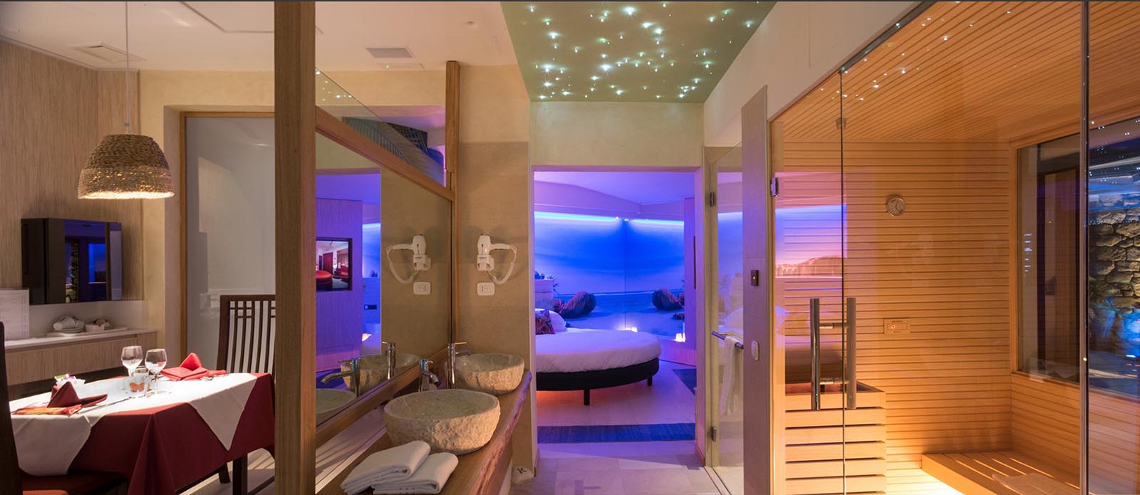 Motel K Pool Villa Seychelles Motel K Pool Villa Seychelles vista sulla zona wellness, sulla sinistra la zona ristorazione interna della suite, sulla destra la sauna finlandese privata, sullo sfondo si intravede il letto matrimoniale rotondo, camera a tema isole dell'oceano indiano