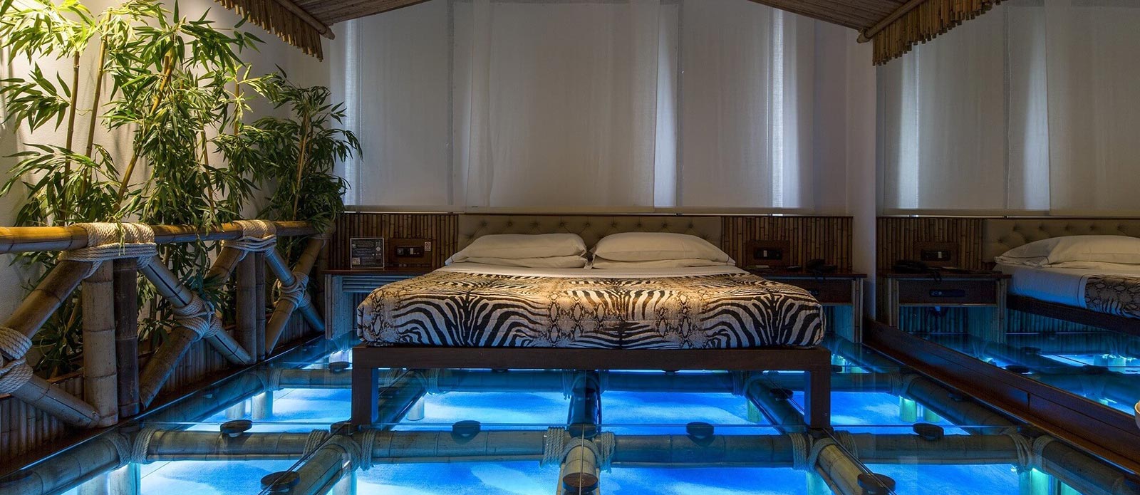 Motel K Senior Suite Laguna Blu Motel K Senior Suite Laguna Blu vista sul letto matrimoniale appoggiato su una palafitta di legno in riva al mare camera a tema isole dell'america centrale