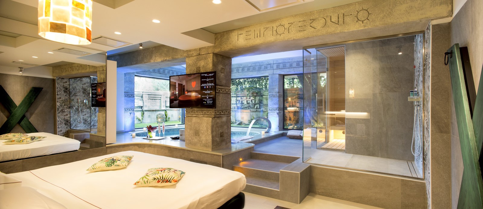 Motel K Wellness Suite Tempio Perduto Motel K Wellness Suite Tempio Perduto vista sul letto matrimoniale, sulla doccia a vista doppia con aromaterapia, sullo sfondo si intravede la mini piscina idromassaggio con cascata, camera a tema atlantide